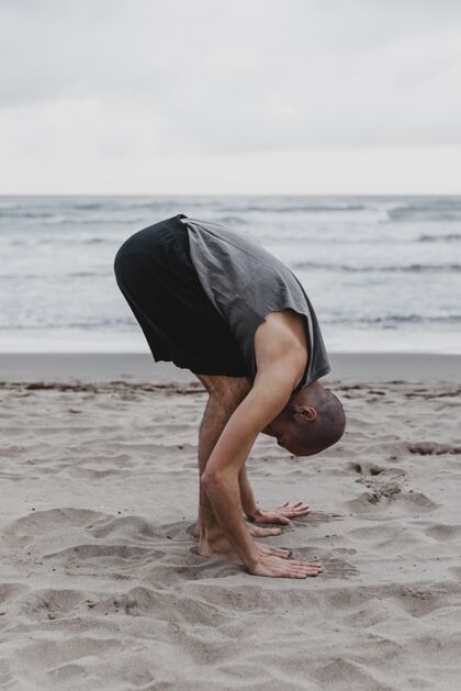 复制海滩上练习瑜伽姿势的男子侧视图冥想户外男性