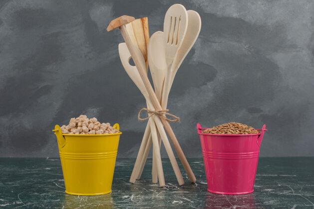 木头厨房工具 大理石桌上放着两桶五颜六色的坚果食物工具粉色