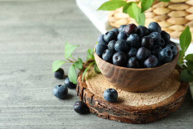 多汁新鲜的浆果概念和蓝莓放在灰色的桌子上蓝莓宏碗